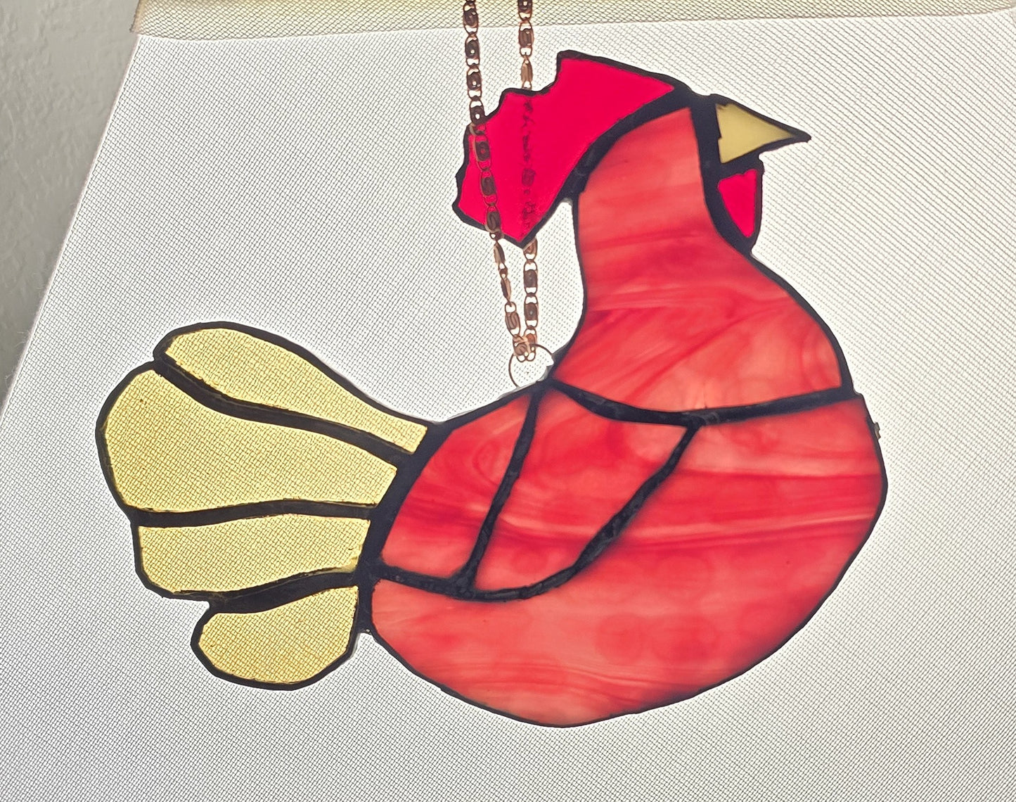Red and yellow bird-shaped ornament on a white background